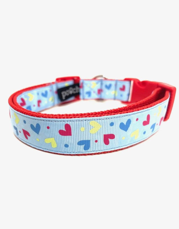 Adjustable pale blue hearts dog collar with red trim and stainless steel D-rings.