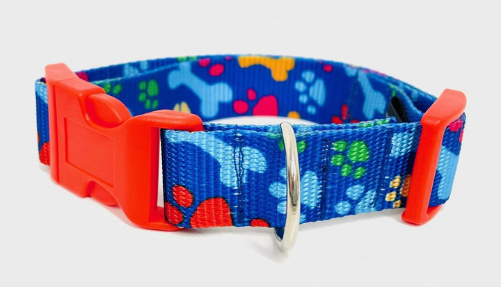 Handmade dog collar with paw prints and bones pattern, featuring a stainless steel D-ring and red plastic clip.