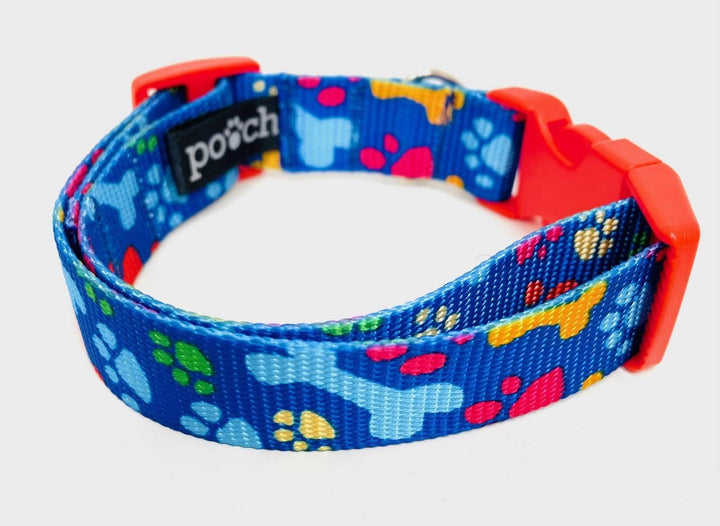 Handmade blue dog collar with paw prints and bones design, featuring a sturdy plastic clip and stainless steel D-ring.
