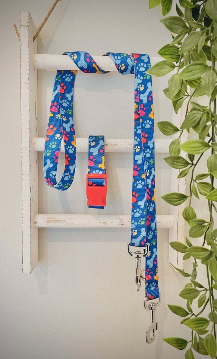 Handmade dog collar with paw prints and bones design, featuring durable materials, adjustable fit, and matching lead.